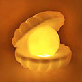 Elegant Pearl Shell Night Lamp glowing softly on a bedside table.