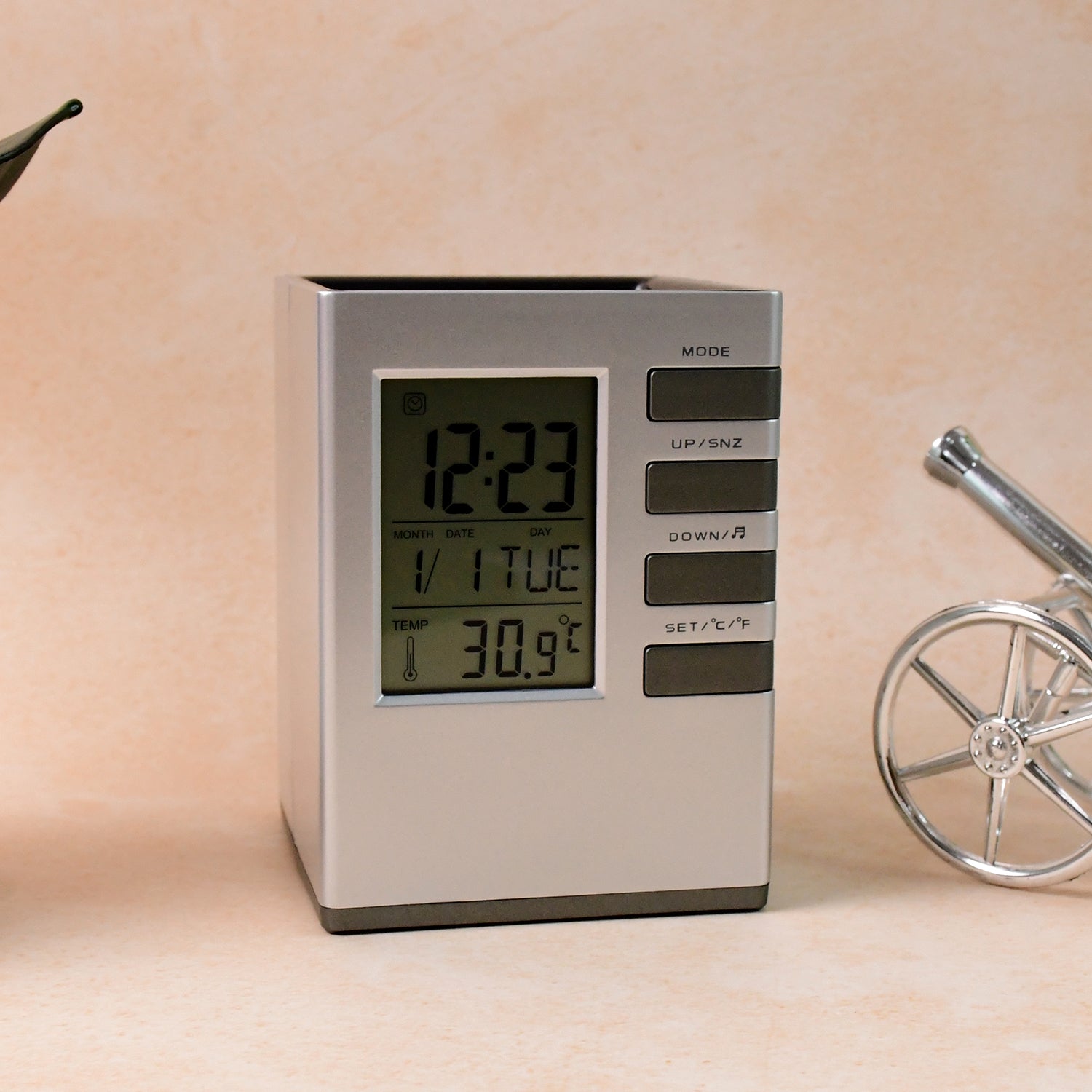 Modern cube digital desk clock with pen holder on white background showing clear digital time