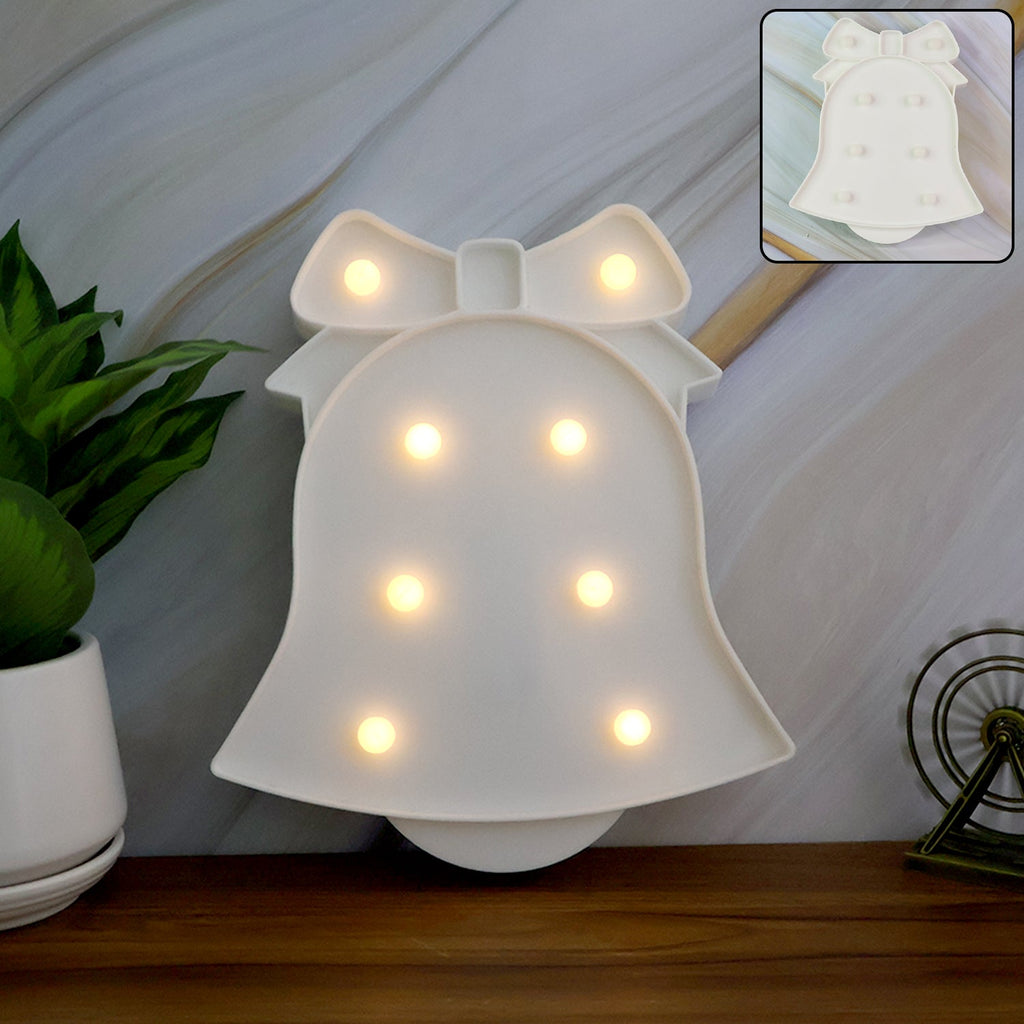 Pink LED Bell Shaped Night Light glowing warmly on wooden table