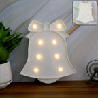 Pink LED Bell Shaped Night Light glowing warmly on wooden table
