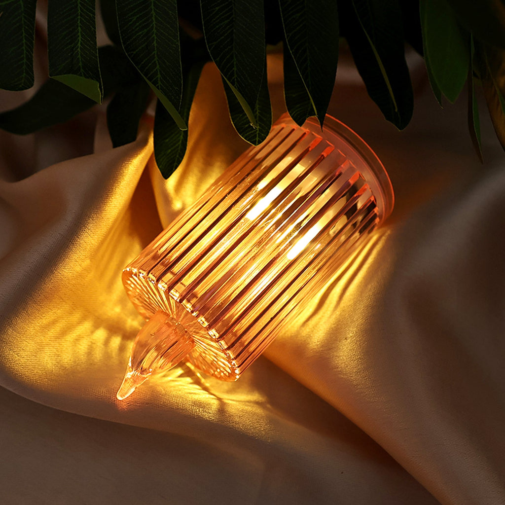Close-up of a flickering LED flameless candle with ribbed design