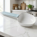 The multi-purpose plastic measuring spoon displayed in a modern kitchen setting.