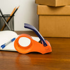 Angled view of the multi-color hand tape dispenser, highlighting its sturdy construction.