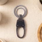 Dual ring metal key holder with single key attached, showing secure grip