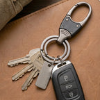 Hand holding compact metal key holder with rotating swivel