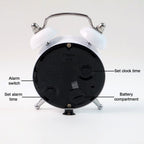 Twin-bell analog alarm clock placed on a modern bedside table.