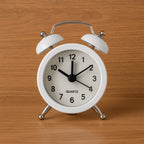 Close-up of a classic twin-bell analog alarm clock face.