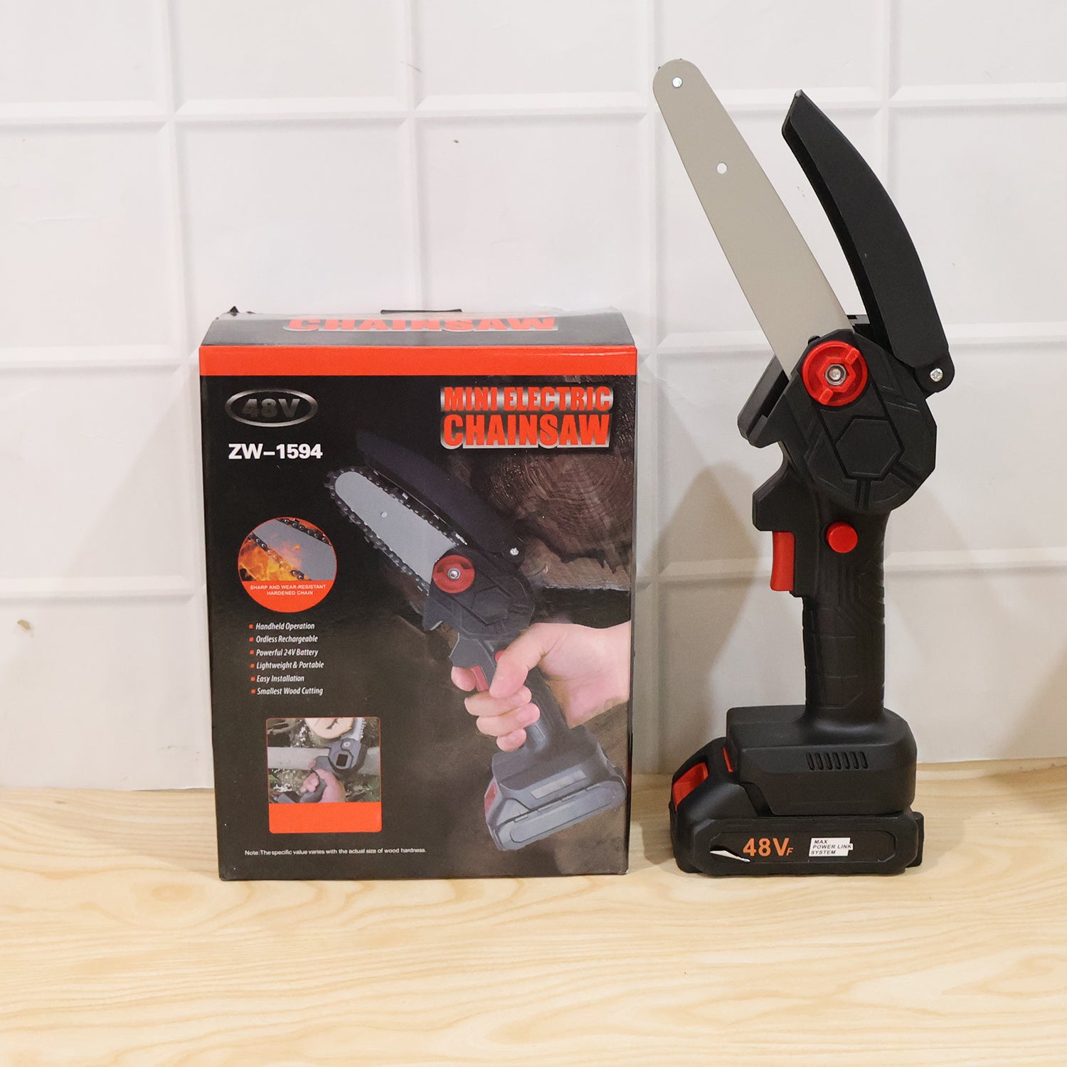 Person using mini cordless electric chainsaw to cut a tree branch
