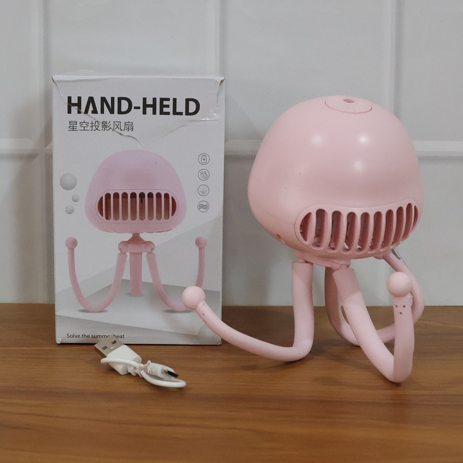 Mini handheld fan with flexible tripod and star projection light in action