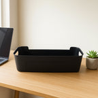 Four black plastic storage trays stacked neatly