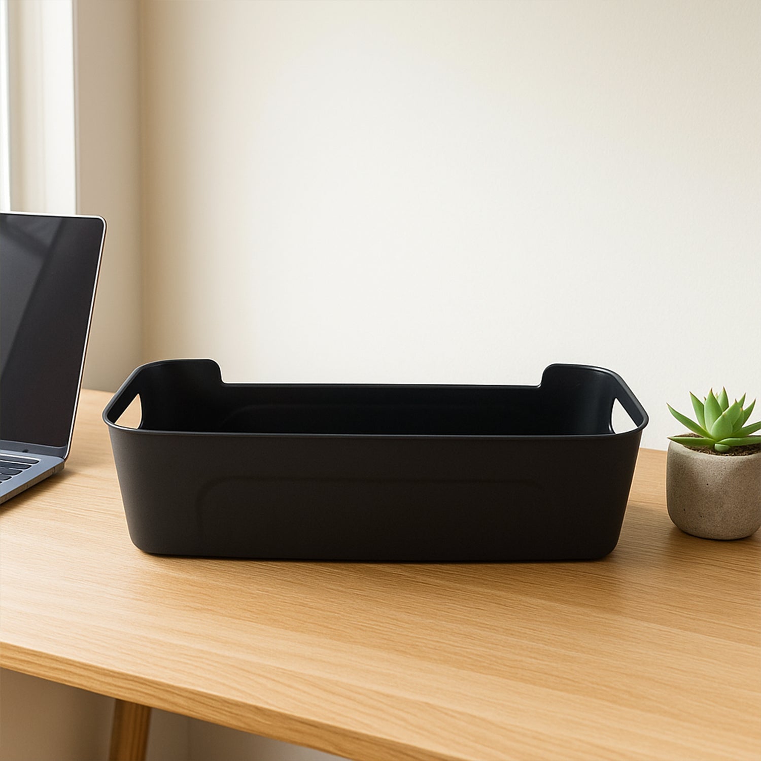 Four black plastic storage trays stacked neatly
