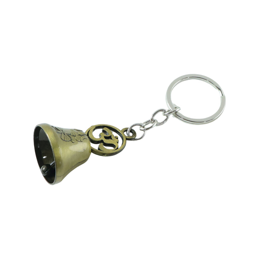 Antique brass Om temple bell keychain displayed on textured surface