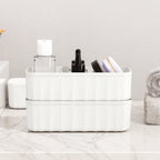 A hand placing folded socks into a 5-compartment drawer organizer for tidy storage.