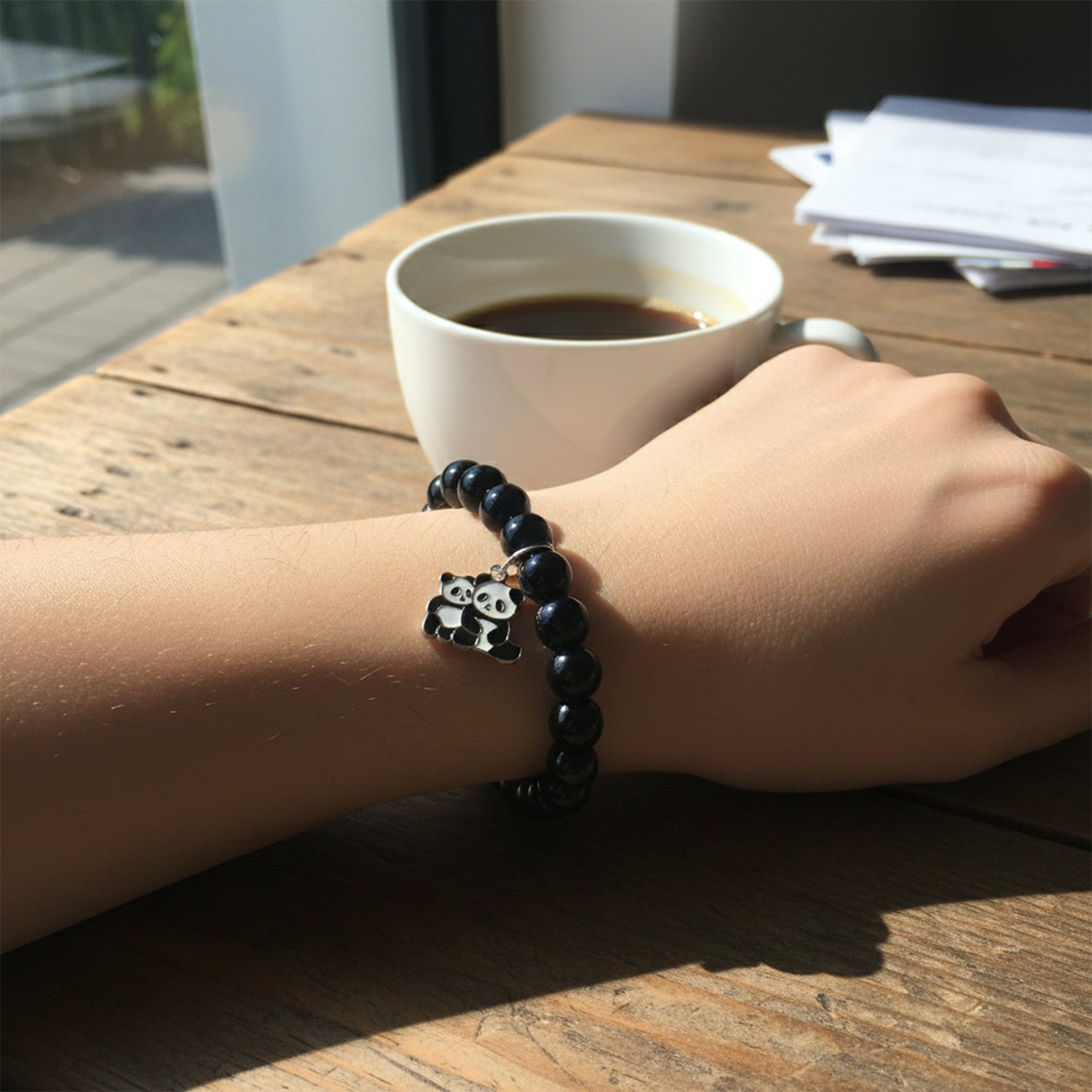 Angled perspective of the black beaded bracelet with panda charm.