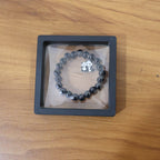 Lifestyle shot of black beaded stretch bracelet featuring cute panda charm on wrist.
