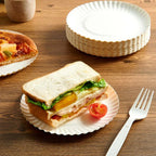Top view of multiple nested Freshee eco-friendly 7 inch compostable paper plates.
