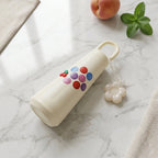 Close-up of bottle handle and flower charm on glass water bottle