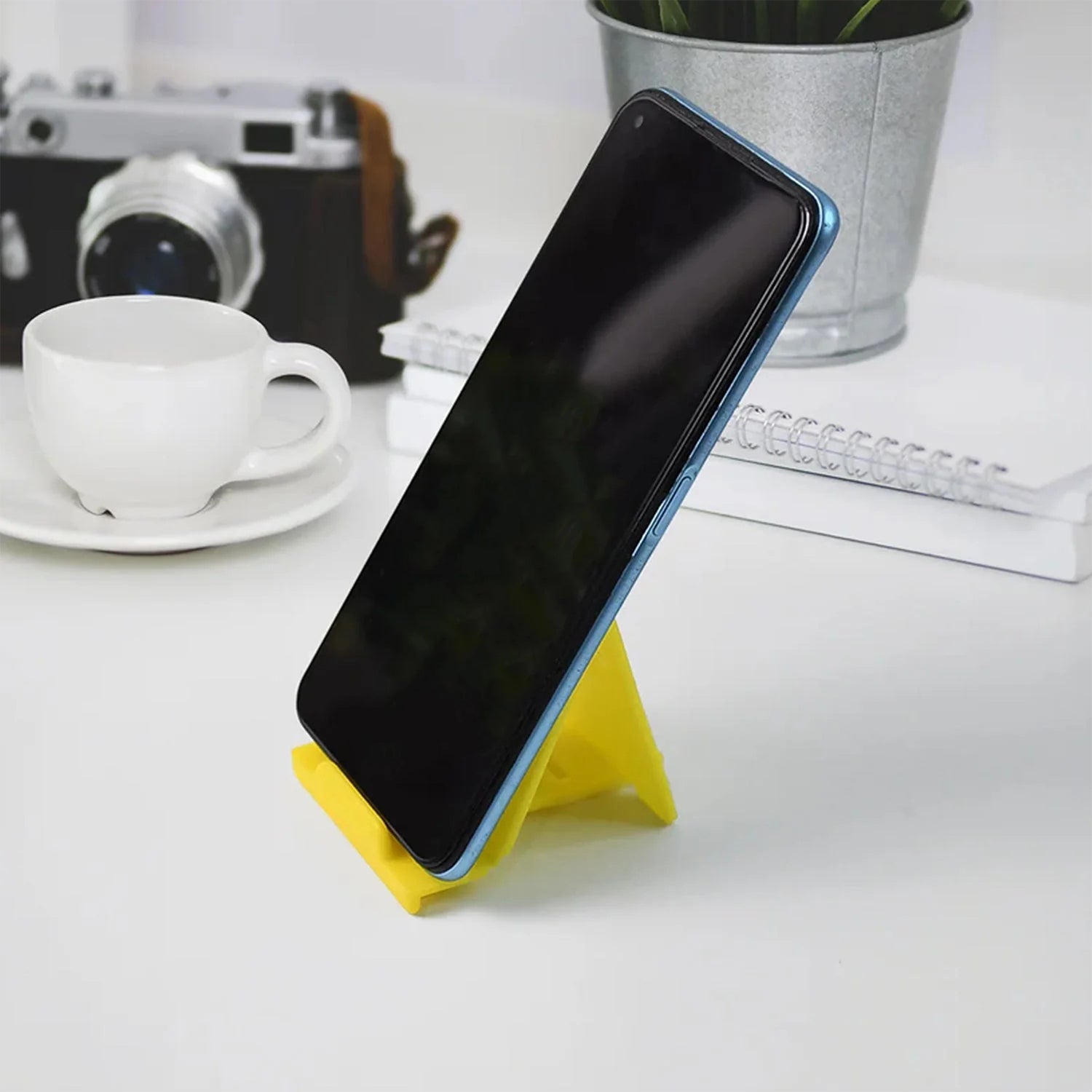 Foldable plastic phone stand in use holding smartphone securely