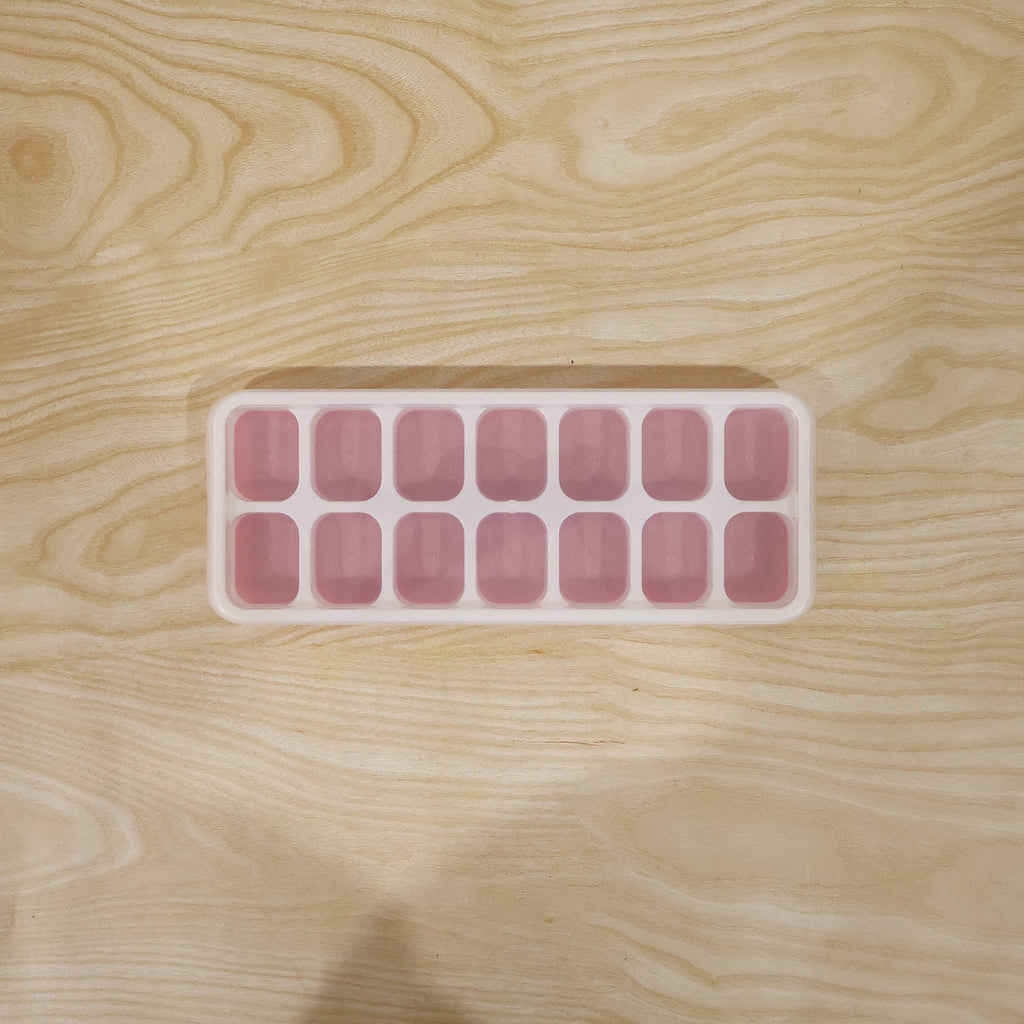 Pink ice cube tray in use for freezing