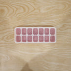 Pink ice cube tray in use for freezing