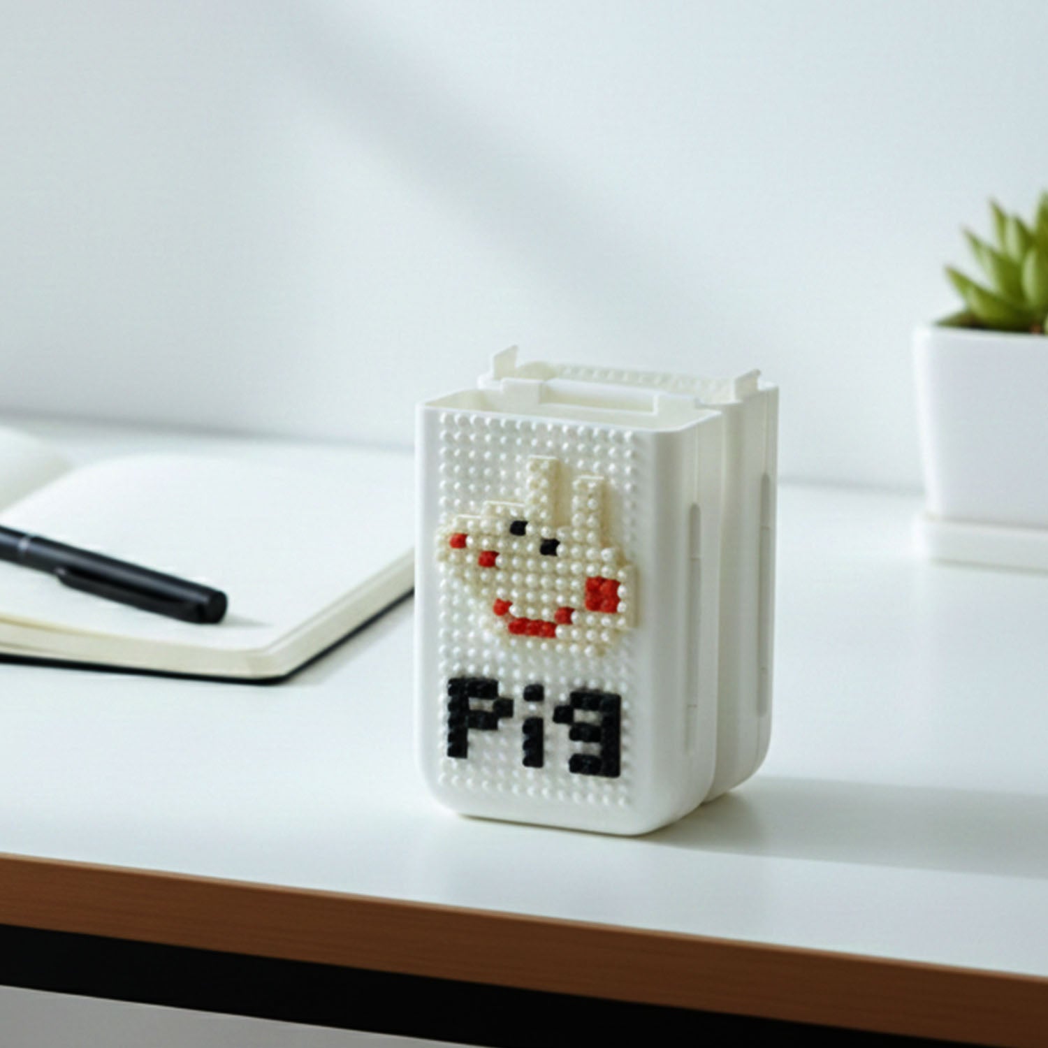 Close-up of pixel art pen holder storing stationery items neatly