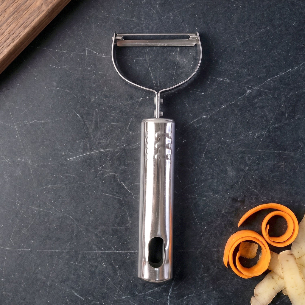 Vegetable peeler tool being used on white background
