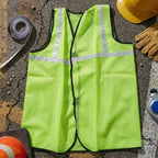 Person wearing the reflective safety jacket while cycling for enhanced road safety.