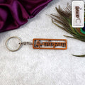Radha Krishna Metal Keychain with laser-cut Hindi inscription and peacock feather motif