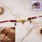 Ganesh charm rakhi with feather pendants on beaded thread