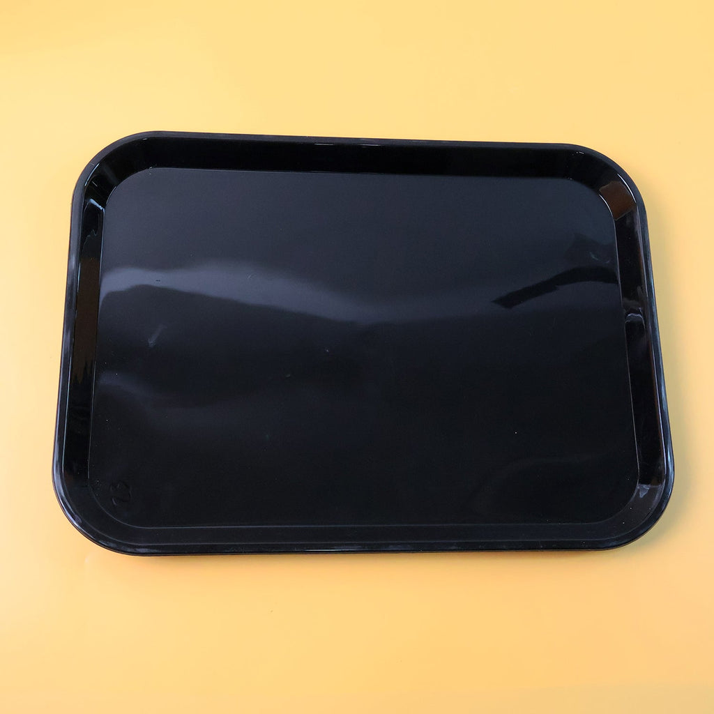Close-up detail of smooth surface and rounded corners on black plastic serving tray
