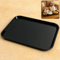 Black plastic serving tray with rectangular shape placed on a plain background