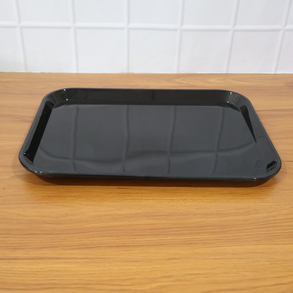 Black plastic serving tray used in home to serve tea cups and snacks