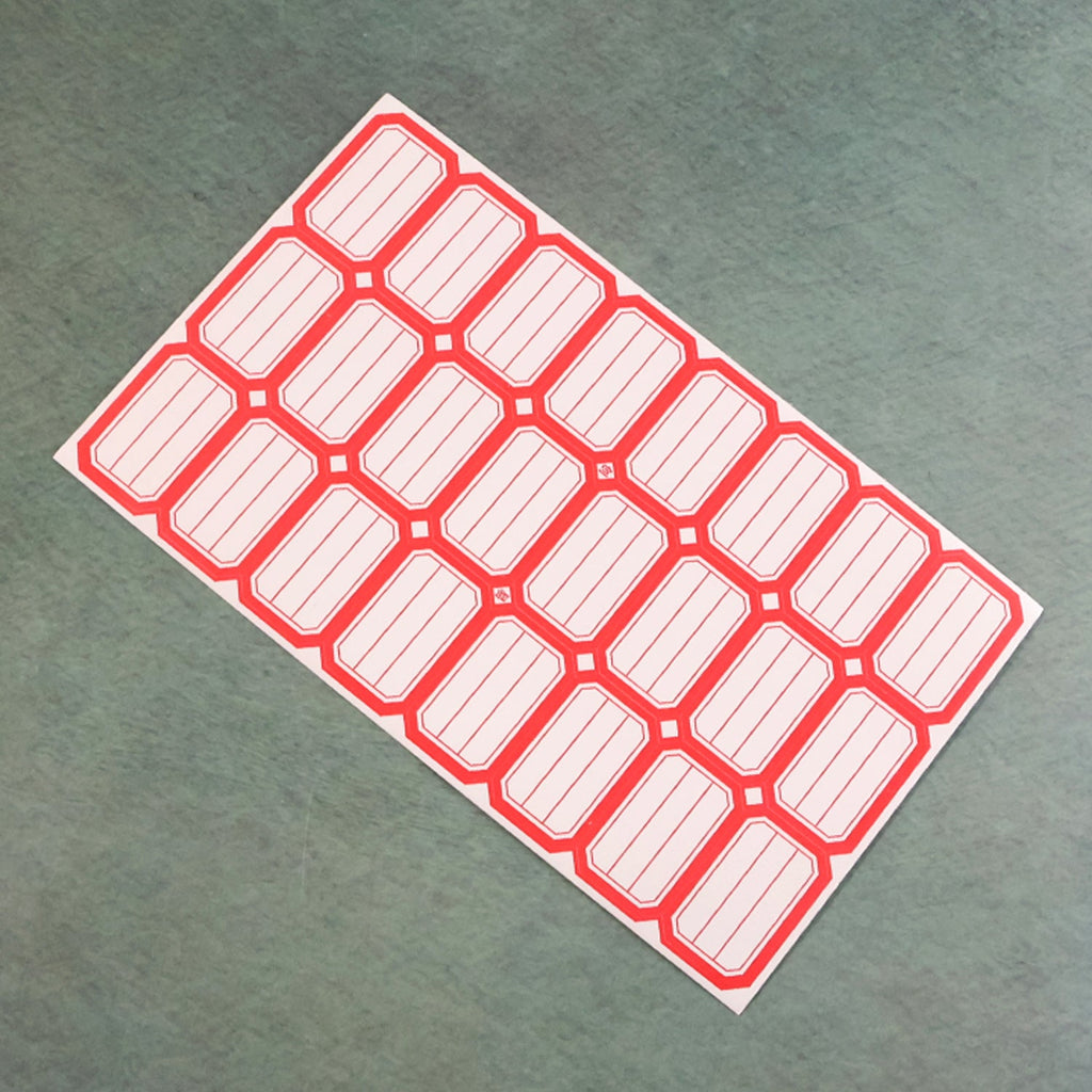 Close-up photograph of red and white self-adhesive rectangular label stickers