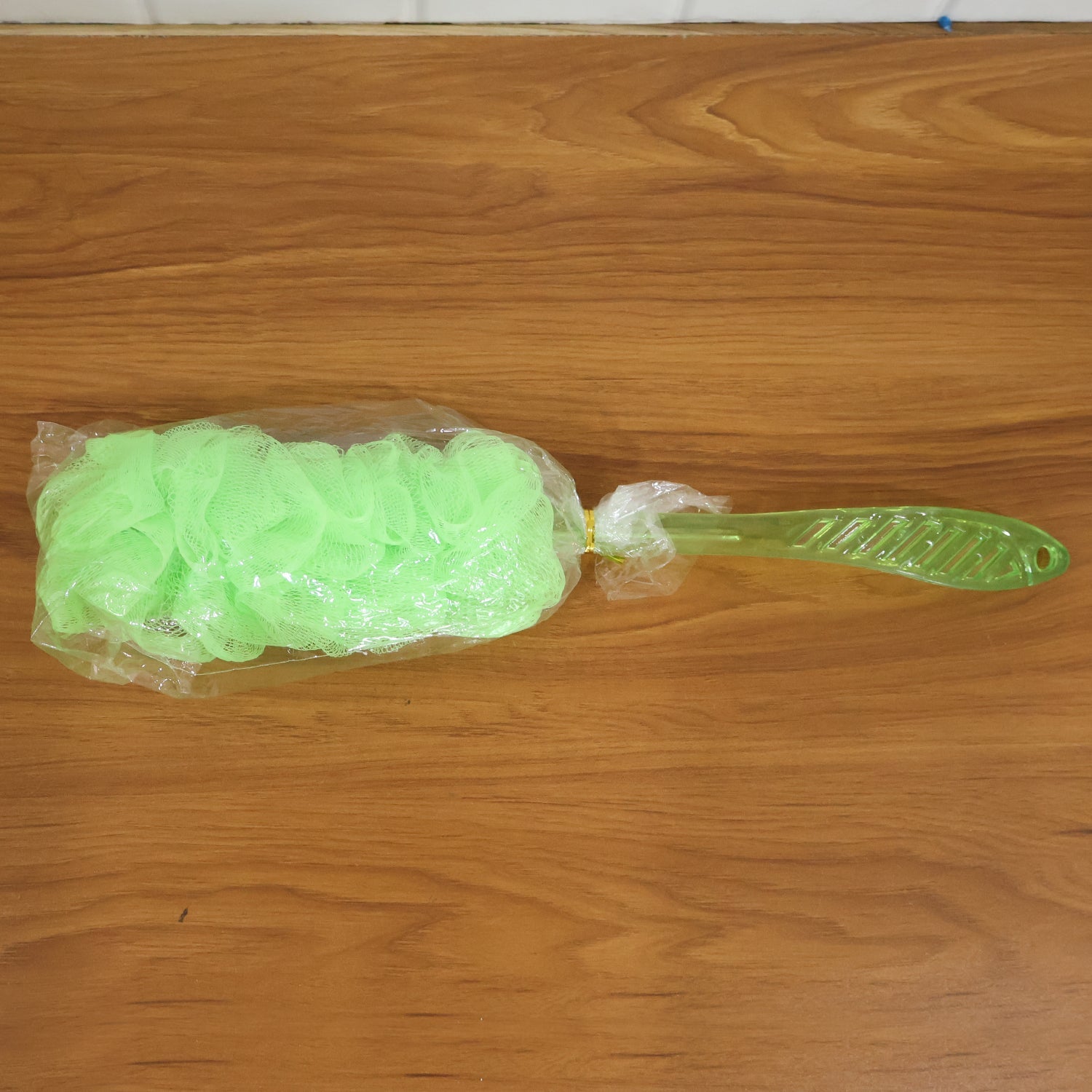 Full view of the bath loofah brush, showcasing its mesh sponge and long handle.