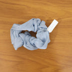 Model wearing soft fabric hair scrunchie in a stylish ponytail