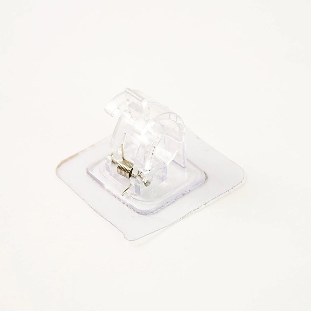 Self-adhesive curtain rail clip installed on wall for lightweight curtains