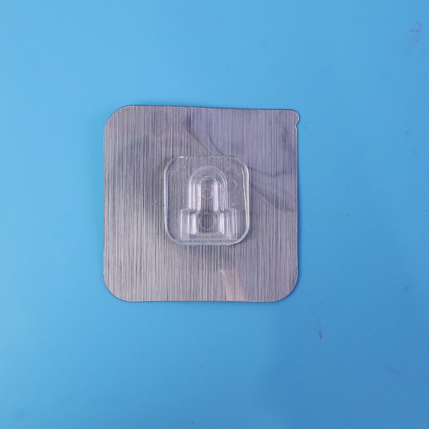 Double-sided transparent adhesive wall hook in use