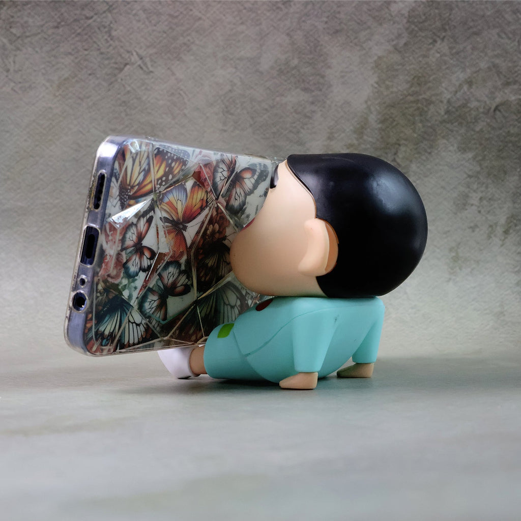 Mobile phone stand featuring a cartoon figurine design on desk