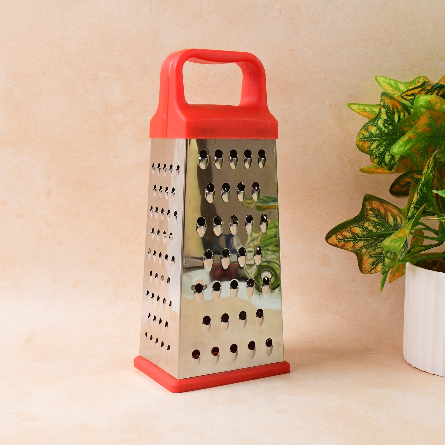 Compact stainless steel kitchen grater and slicer tool with secure base