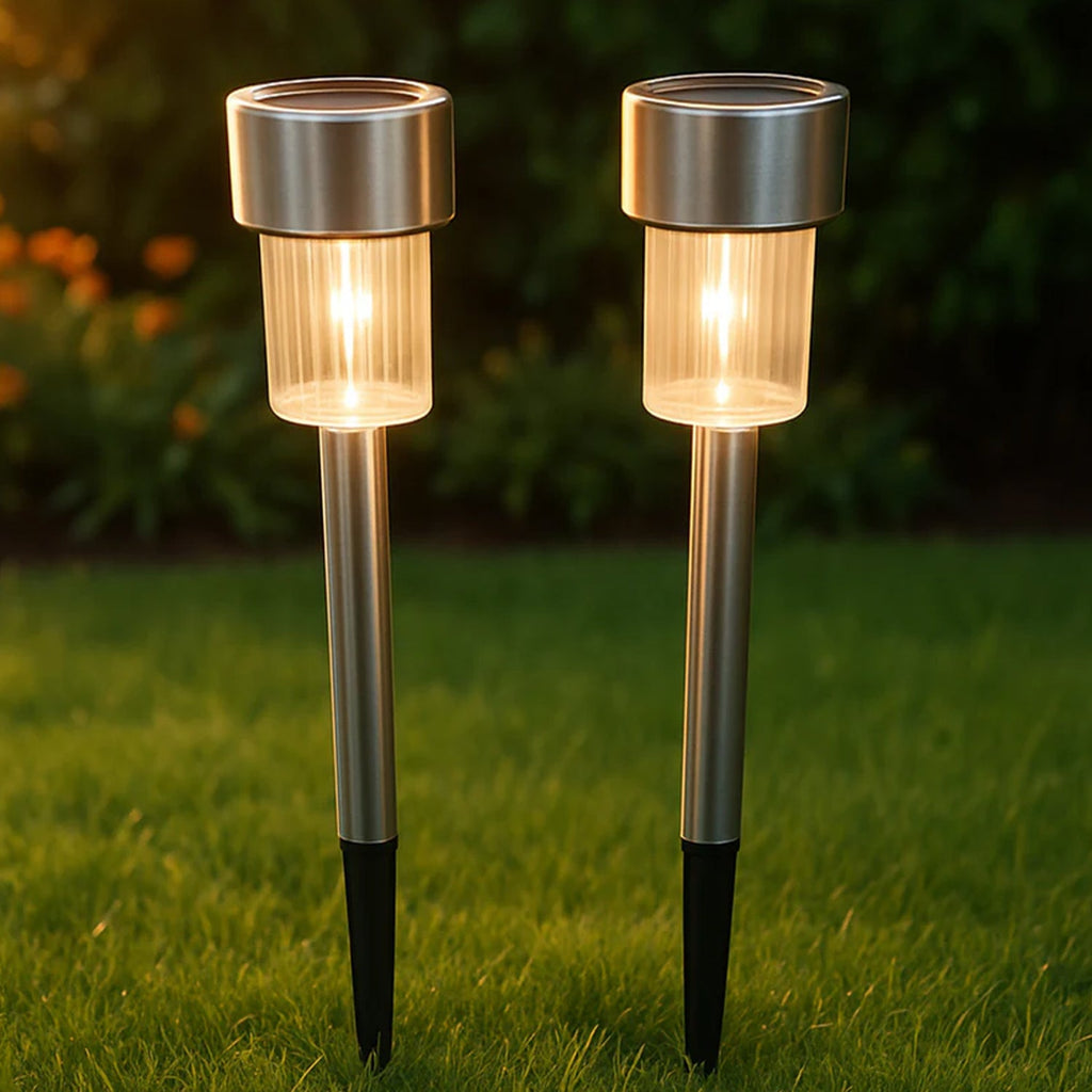 Lifestyle image showing  solar lawn lamps illuminating garden edge