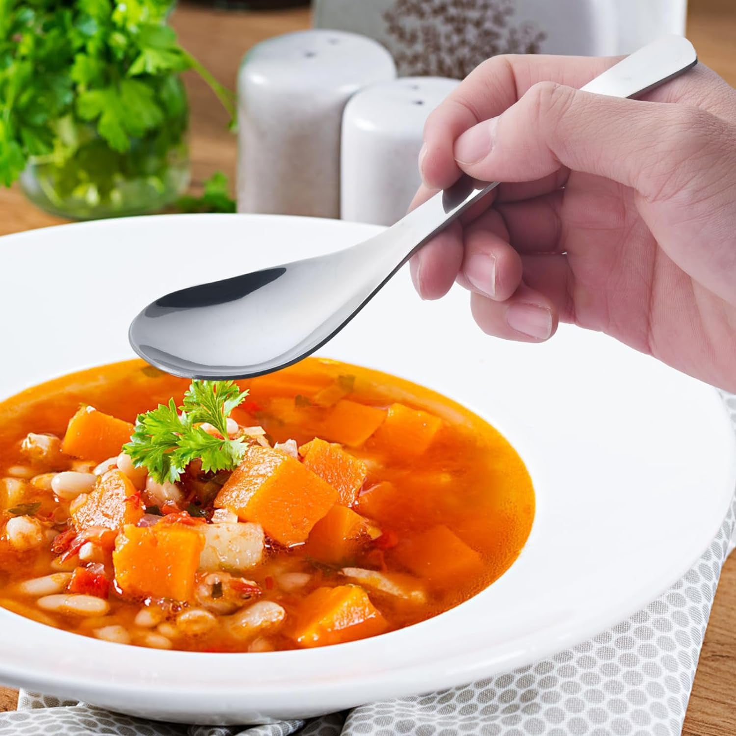 Ergonomic handle and smooth edges of the durable stainless steel soup spoon.