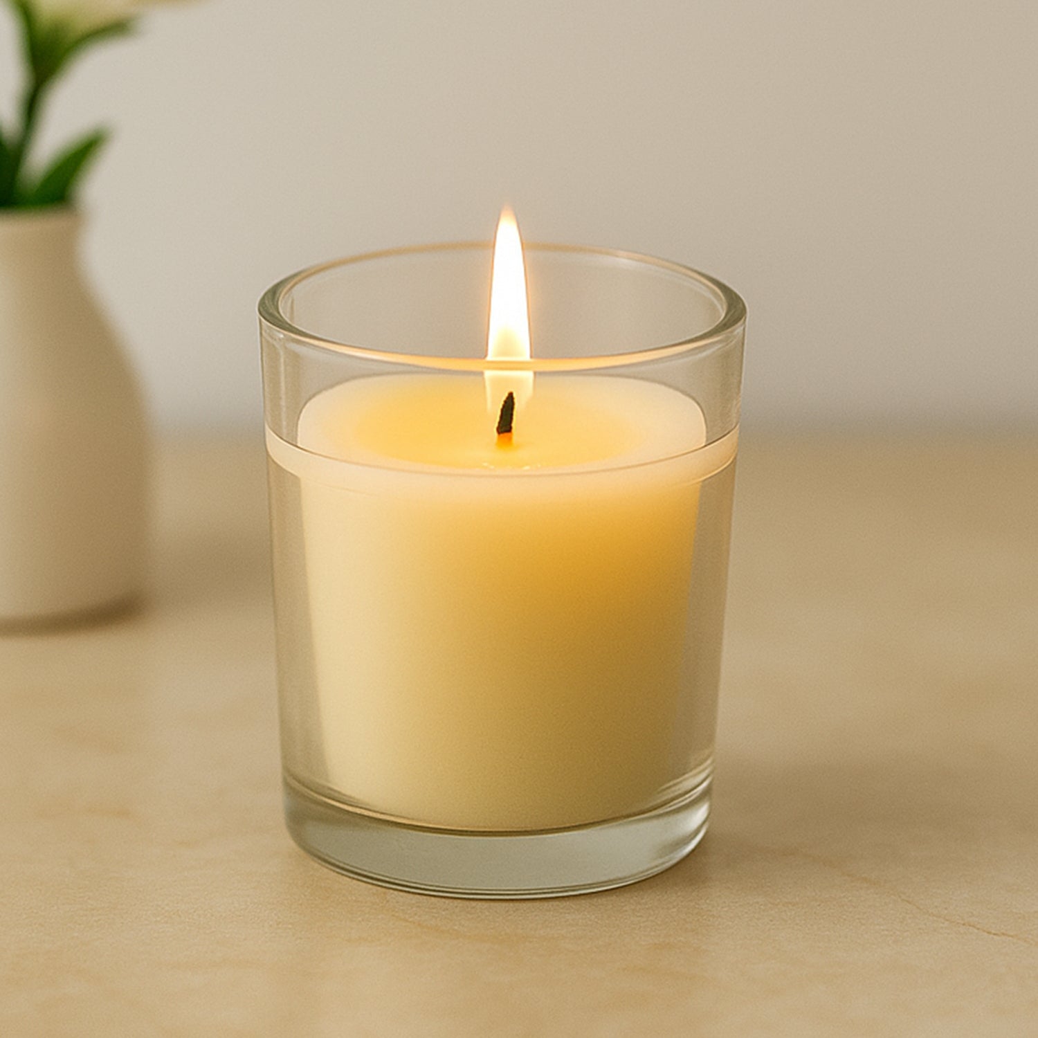 Soy blend scented candle in its elegant clear glass holder.