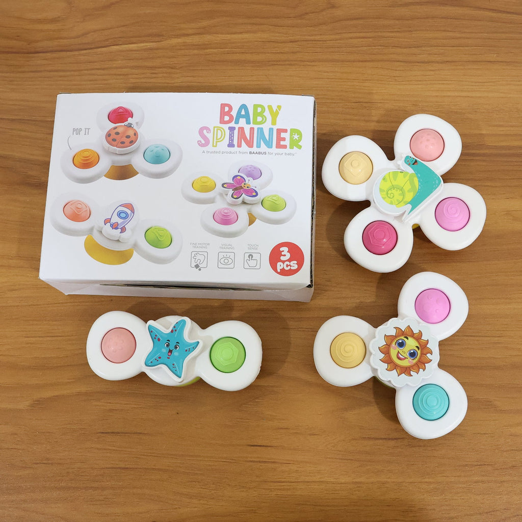 Baby playing with white suction-based spinner toys promoting sensory skills