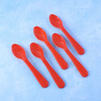 The 5-piece plastic spoon set sealed securely in clear retail packaging, ready for use.