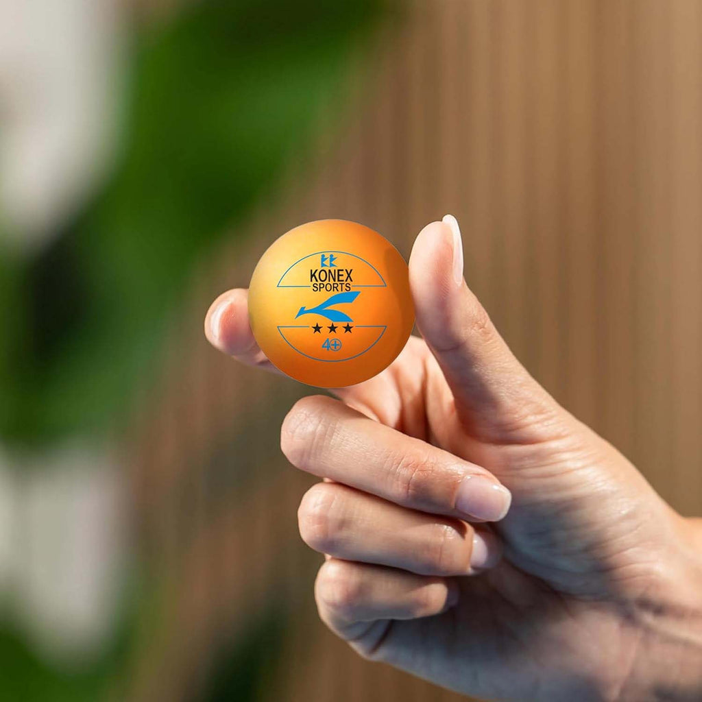 Orange 3-star professional ping pong balls on a table surface