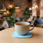 Heat-resistant coaster shielding a wooden table from hot pot heat marks