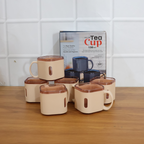 Square tea cup held in hand highlighting transparent rim