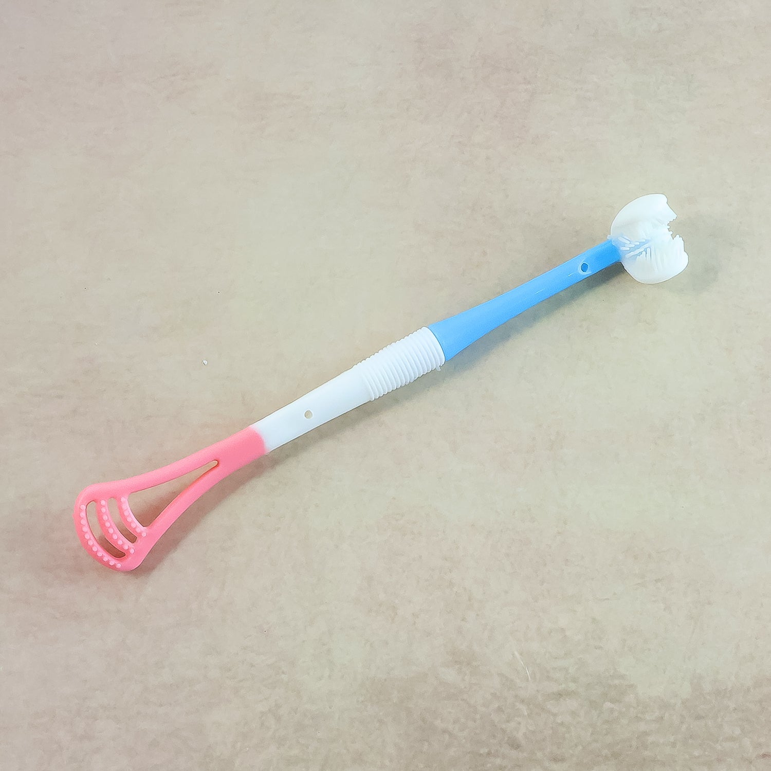 Baby tongue cleaner showing soft brush and scraper ends for oral care