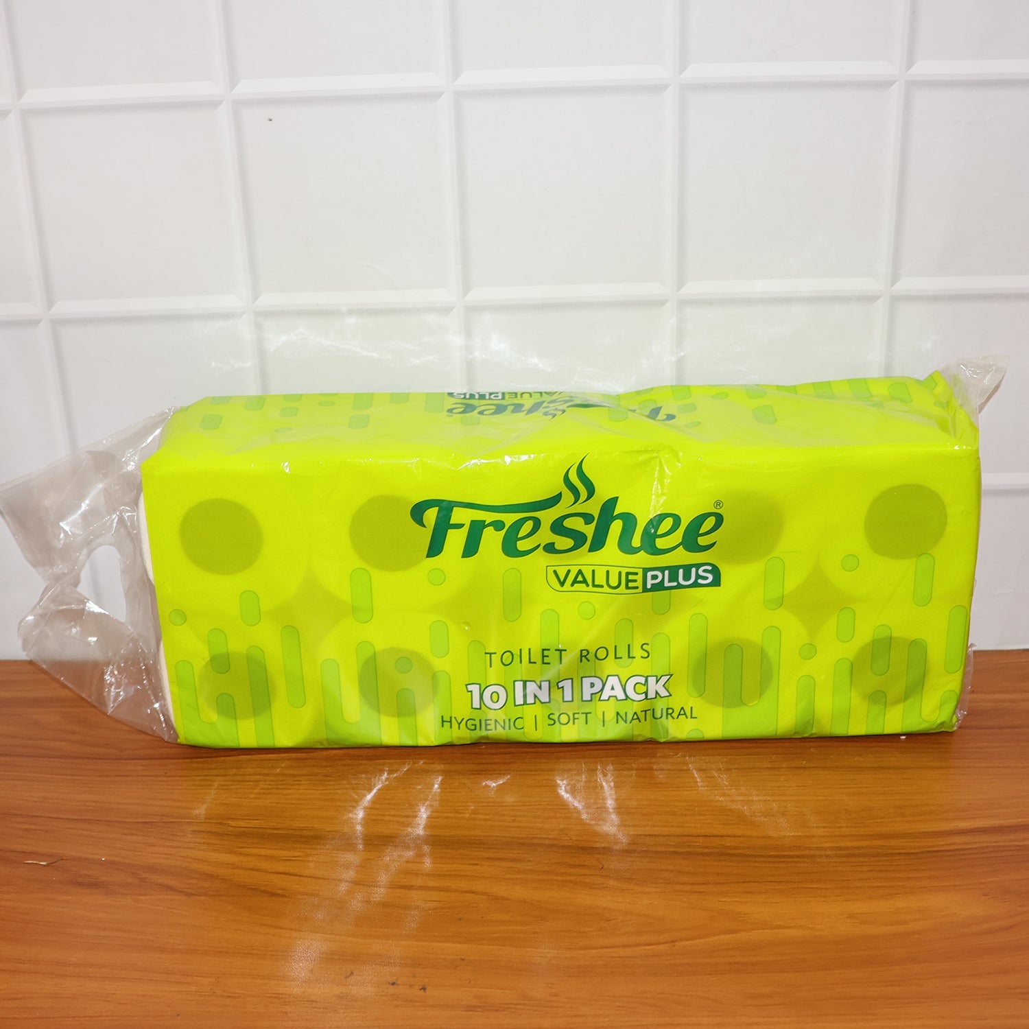 A Freshee toilet tissue roll being used from a holder, showing ease of dispensing.