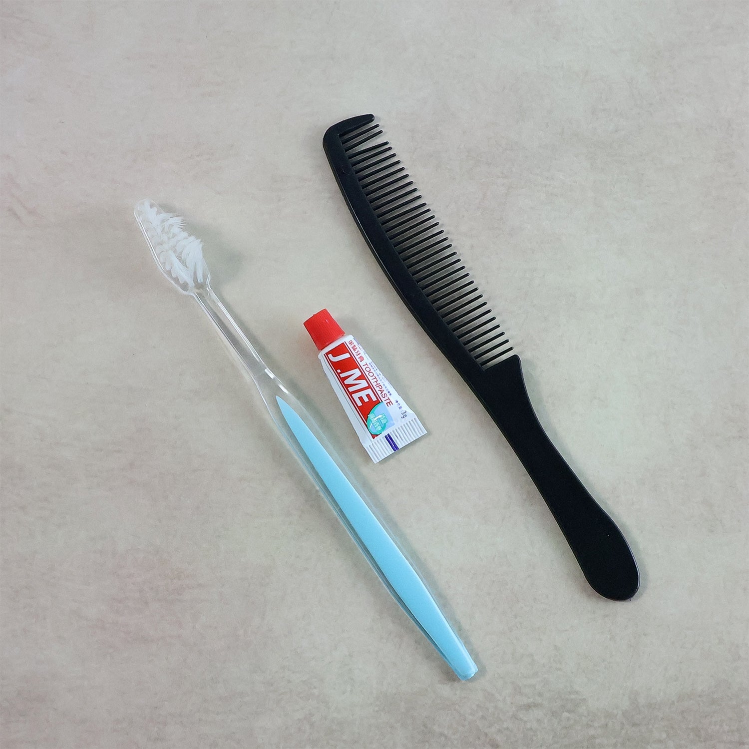 Compact Travel Hygiene Kit with toothbrush, toothpaste tube, and comb arranged neatly